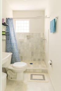 a white bathroom with a toilet and a shower at Villa Bonita Torre 11 3 in Cozumel +20 photos