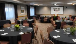 a conference room with tables and chairs and a screen at Canal Park Lodge in Duluth