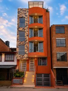 an orange building with a staircase in front of it at Hospedaje Edificio Alejandria in Sogamoso