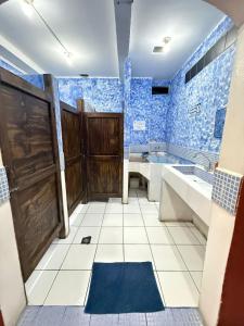 a bathroom with blue tiled walls and a wooden door at Cristales de Antigua La Calzada in Antigua Guatemala
