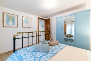a bedroom with a bed with a blue and white bedspread at Alpujarra Relax with Terrace in Órgiva