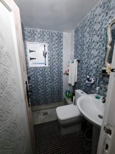 a bathroom with a white toilet and a sink at La maison des oliviers in Houmt Souk +17 photos