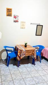 a table with two blue chairs and a table with a tablecloth at República Nunes e Silva in Vilhena +7 photos