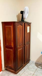 a wooden cabinet with a fan on top of it at República Nunes e Silva in Vilhena