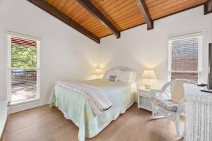 a bedroom with a bed and a chair and windows at Sues Lake House in Buford