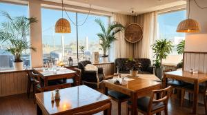 a restaurant with tables and chairs and large windows at Pinamar Beach Resort in Pinamar