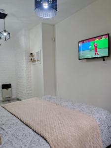 a bedroom with a bed with a tv on the wall at Moderno Estudio PB - Entrada Autónoma, Equipado y Cerca de Todo in Mendoza
