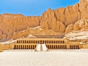 a building in front of a rocky mountain at Grand Backpackers Hostel Luxor in Luxor