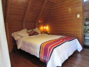a bed in a room with a wooden wall at Edén del Aliso in Santa Barbara