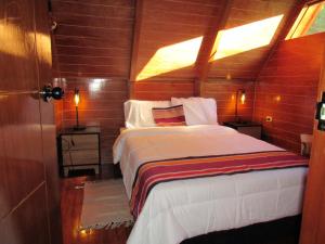 a bedroom with a large bed in a wooden room at Edén del Aliso in Santa Barbara +1 photo