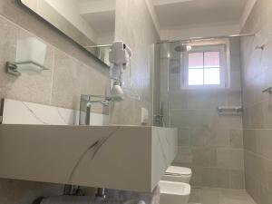 a bathroom with a sink and a toilet and a window at Vila Élysée in Spille