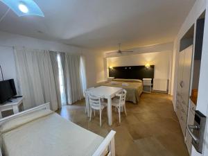 a room with a bed and a table and chairs at Brisa Marina Apart Hotel in Pinamar