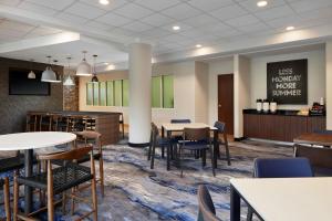 a dining room with tables and chairs and a tv at Fairfield Inn & Suites by Marriott Stafford Quantico in Stafford