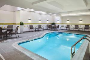 a pool in a hotel room with tables and chairs at Fairfield Inn & Suites by Marriott Stafford Quantico in Stafford