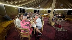 a group of people sitting at a table in a tent at Atta Desert Camp in El Gouera