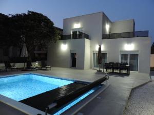 a villa with a swimming pool in front of a house at Villa RoseMary in Split
