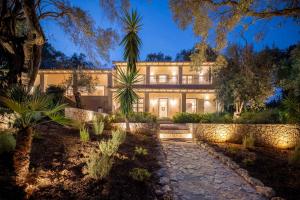 an exterior view of a home at night at Apelia Estate - Among Ancient Olives, Experience the Quiet Soul of Corfu in Corfu