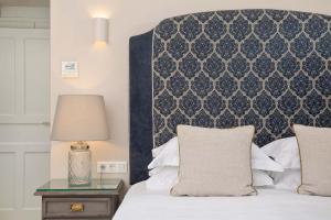 a bedroom with a bed with a black and white headboard at Apelia Estate - Among Ancient Olives, Experience the Quiet Soul of Corfu in Corfu