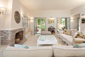 a living room with couches and a fireplace at Apelia Estate - Among Ancient Olives, Experience the Quiet Soul of Corfu in Corfu +58 photos