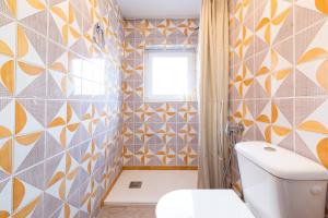 a bathroom with a toilet and a window at Alpujarra Relax with Terrace in Órgiva +120 photos