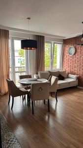a living room with a couch and a table and chairs at Apartament Grochowa in Białystok