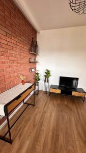a room with a brick wall and a bed and a laptop at Apartament Grochowa in Białystok