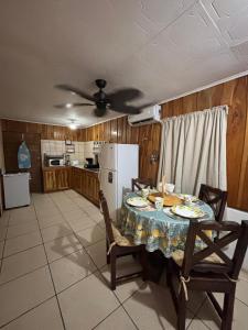 a kitchen with a table and chairs and a refrigerator at Mapi's House in Paquera
