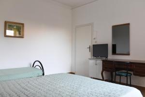 a bedroom with a bed and a desk and a television at Harit16 in Lecce