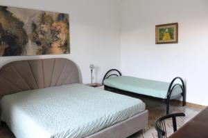 a bedroom with two beds and a painting on the wall at Harit16 in Lecce