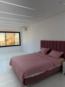a bedroom with a large bed with pink pillows at Villa VIP in Midoun +5 photos