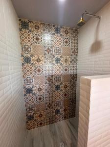 a bathroom with a tiled wall with a shower at Solarte Hostel in Vergara