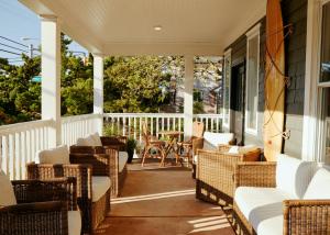 a screened porch with wicker chairs and a table at The Bentley Inn in Bay Head +19 photos