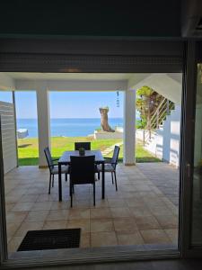 a dining room with a table and chairs and the ocean at Luna del Mare in Ligia