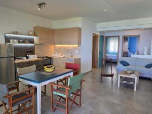 a kitchen and living room with a table and chairs at Luna del Mare in Ligia