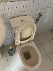 a bathroom with a toilet with the seat up at Guest house in Hārer
