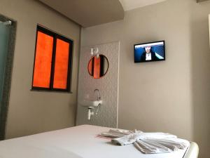 a room with a bed and a tv on the wall at Hotel Alfama Motel in Salvador