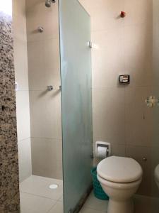 a bathroom with a toilet and a glass shower at Hotel Alfama Motel in Salvador