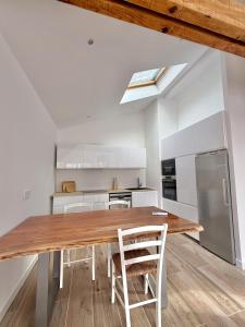 a kitchen and dining room with a wooden table and chairs at Bed & Breakfast L'Etape Basque in Bidart