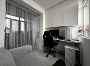 a room with a desk with a chair and a computer at Білі апартаменти in Dnipro