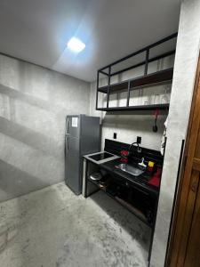 a small kitchen with a stainless steel refrigerator at FLAT PALLADIUM - de frente in São Vicente +11 photos