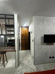 a living room with a table and a wooden door at FLAT PALLADIUM - de frente in São Vicente