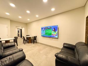 a waiting room with couches and a tv on a wall at Império Hotel in Santos