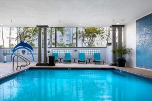 a swimming pool with blue chairs in a building at Peacock Suites in Anaheim