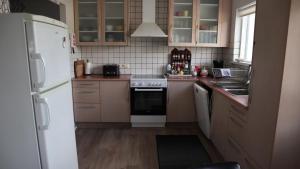 a kitchen with a white refrigerator and a stove at Guesthouse Maddy in Húsavík