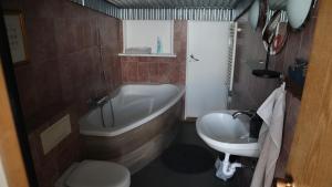a bathroom with a tub and a toilet and a sink at Guesthouse Maddy in Húsavík +36 photos