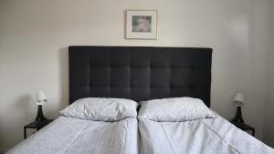 a bed with a black headboard in a bedroom at Guesthouse Maddy in Húsavík