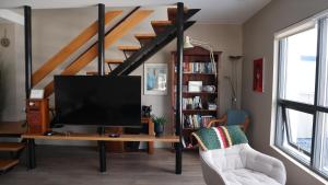a living room with a tv and a book shelf at Guesthouse Maddy in Húsavík