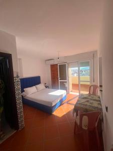 a bedroom with a bed and a window and a chair at Residence Jamal Only Family in Martil