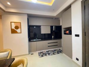 a kitchen with white cabinets and black appliances at Designer Boutique Hotel Serviced Apartments Bahria Town Islamabad & Rawalpindi - LMY in Rawalpindi