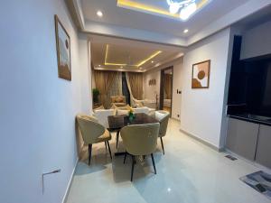 a dining room with a table and chairs and a living room at Designer Boutique Hotel Serviced Apartments Bahria Town Islamabad & Rawalpindi - LMY in Rawalpindi
